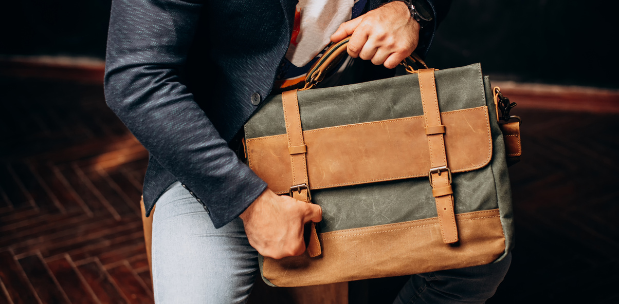 Man hold brown canvas organizer bag in hand